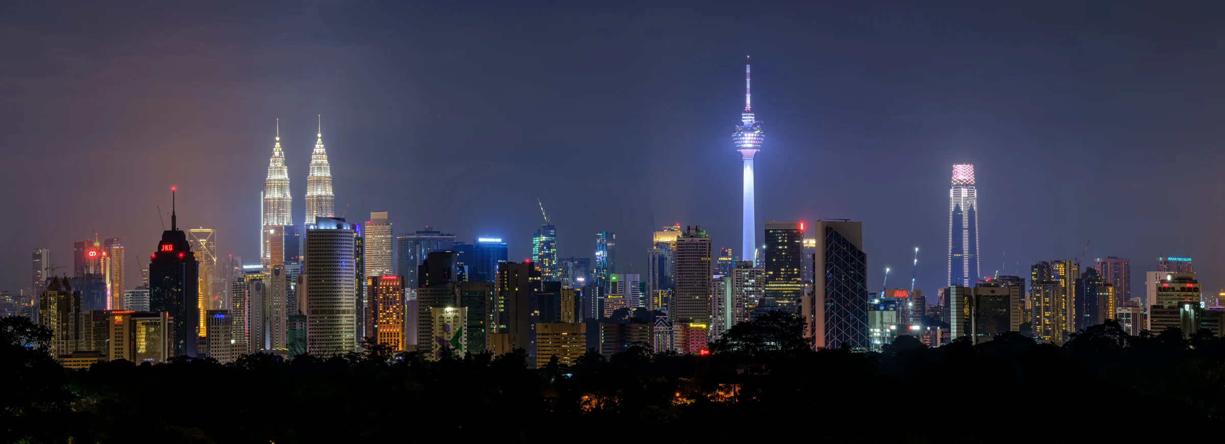Kuala Lumpur skyline at night, with the Petronas Towers and KL Tower